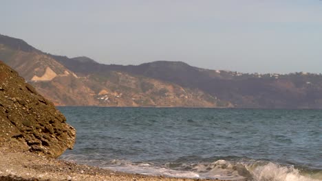 Vista-Al-Mar-De-ángulo-Bajo-En-Cámara-Lenta-Con-Olas-Y-Tierra-A-Distancia