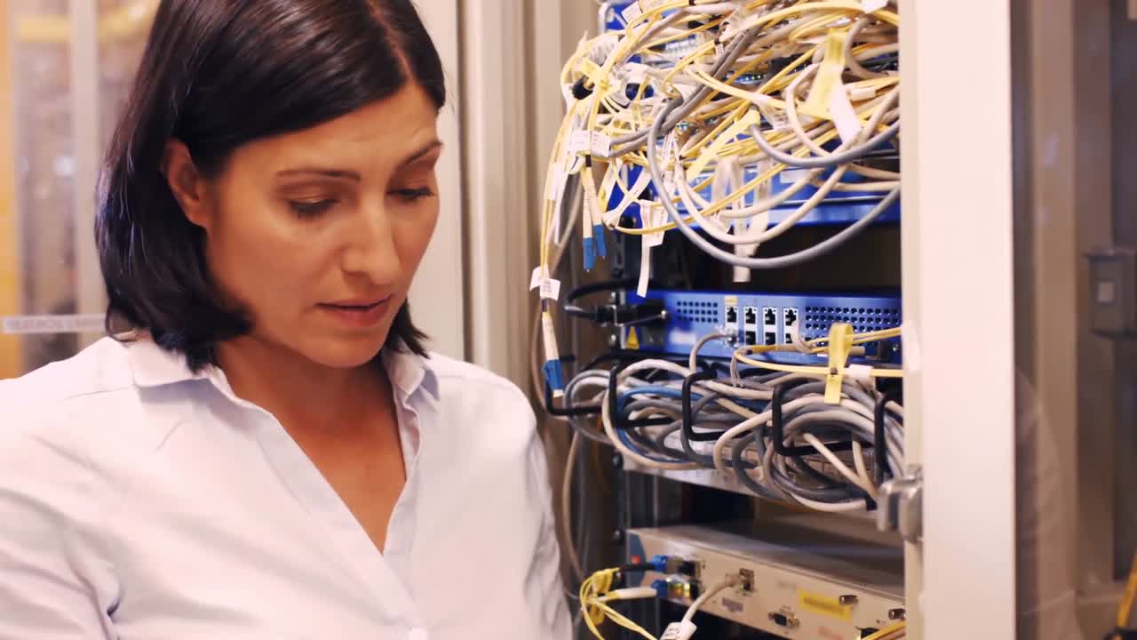 técnico comprobando los cables en un servidor montado en un rack
