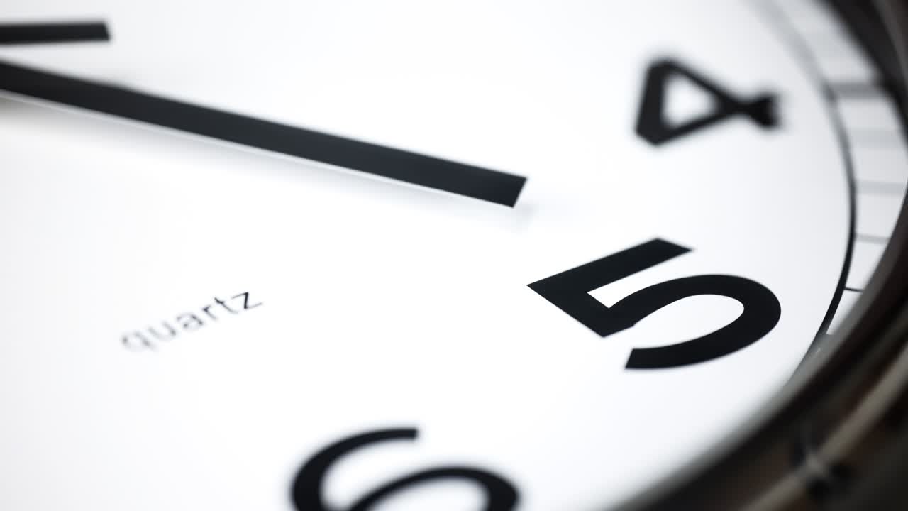 Close-up time lapse of a  modern wall clock. Selective focus on the number 5