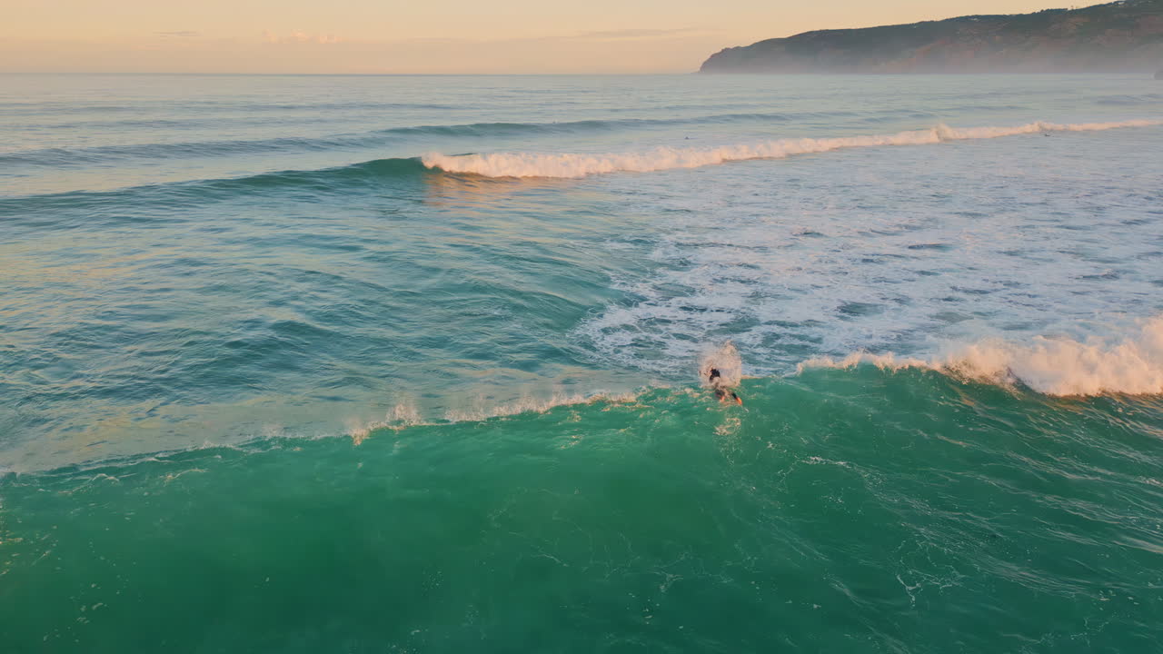 Vista aerea di un surfista sconosciuto che cavalca le onde dell'oceano con la tavola. Surfista estremo.