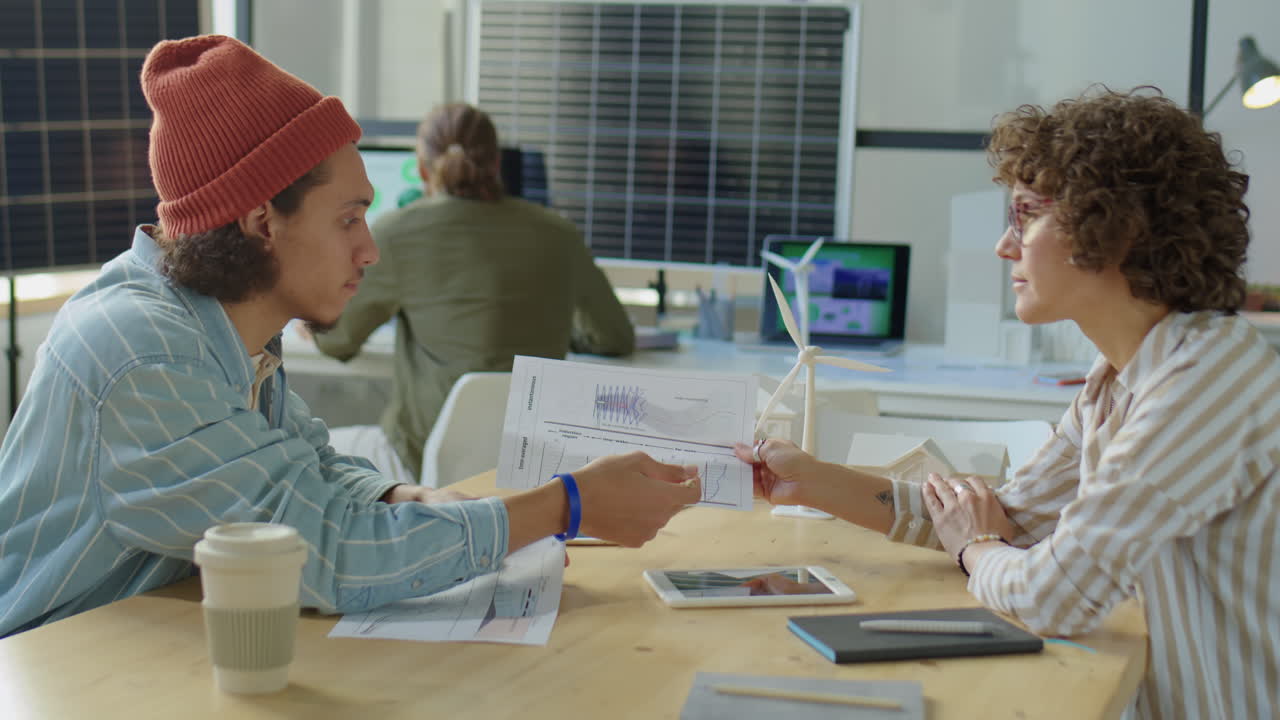 Coworkers Discussing Sustainable Energy Project in Office