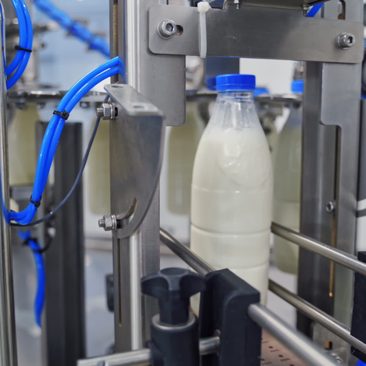 Milk production line at dairy factory. Automated production line at milk factory. Modern plant for bottling milk in plastic bottles.