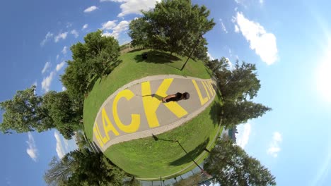 skating over a yellow painted black lives matter mural on pathway with 360 camera