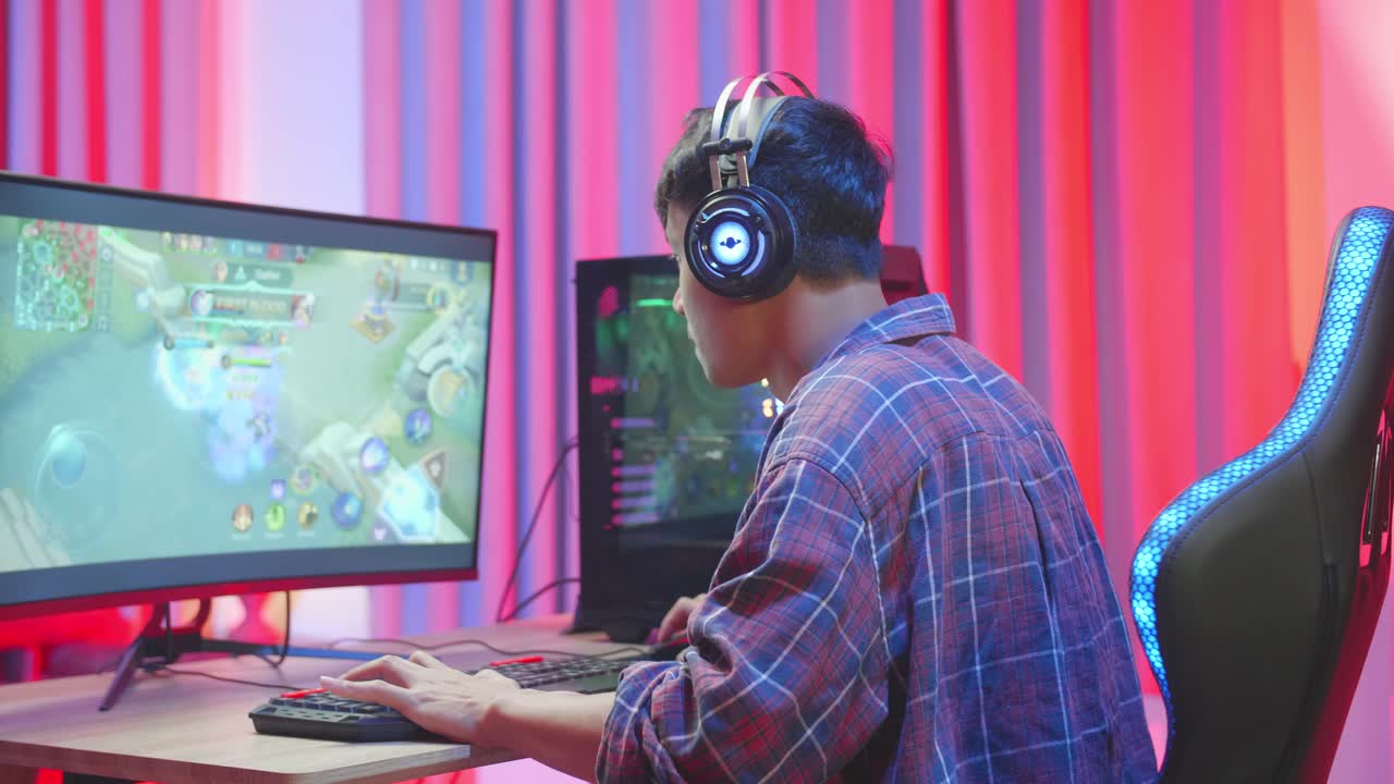 Asian Gamer Man With Headphones Plays Video Game