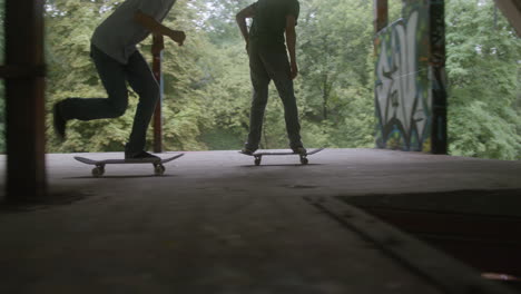 chicos caucásicos patinando en un edificio en ruinas.