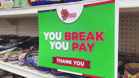 sign warning shoppers at a mexican shop informing them that they will be held accountable in the event they break any merchandise in the shop