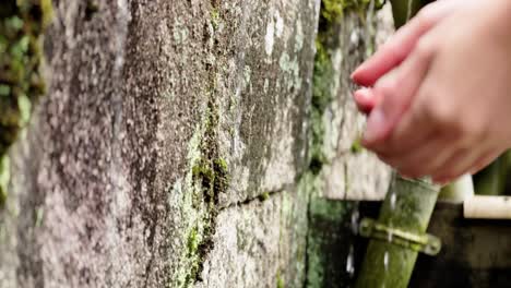 Washing-Hands-Outdoors,-Dripping-Water-Next-to-Stone,-Close-Up,-Static-Shot,-Japan