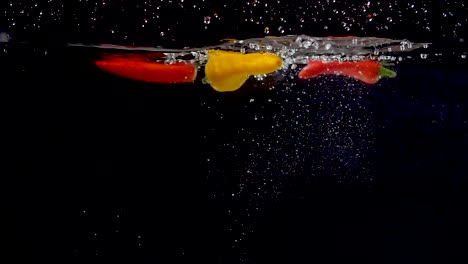 vibrant yellow sweet pepper being dropped into water in slow motion