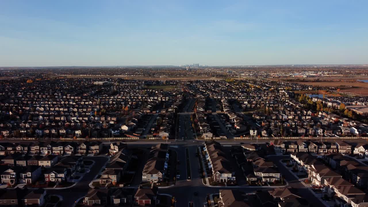una toma aérea del centro de calgary en el fondo con la comunidad de silverado en primer plano