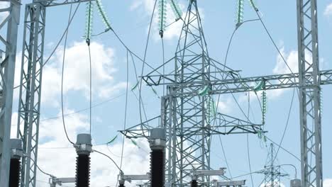 muchos aislantes eléctricos de alto voltaje en la subestación de energía contra un fondo de cielo azul