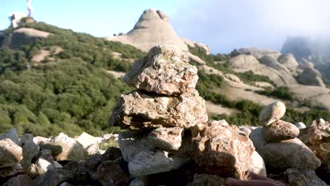 pareja de manos apilando rocas al lado de un valle de piedra