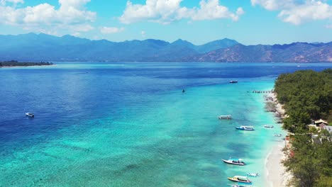 vivid colors of beautiful tranquil seashore of tropical island with boats anchoring on calm water of turquoise lagoon on a bright sky background with white clouds