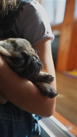 niño sosteniendo a un cachorro dormido