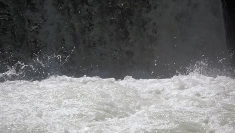 slow motion shot of crashing and splashing waterfall during sunny day in swiss alp mountains