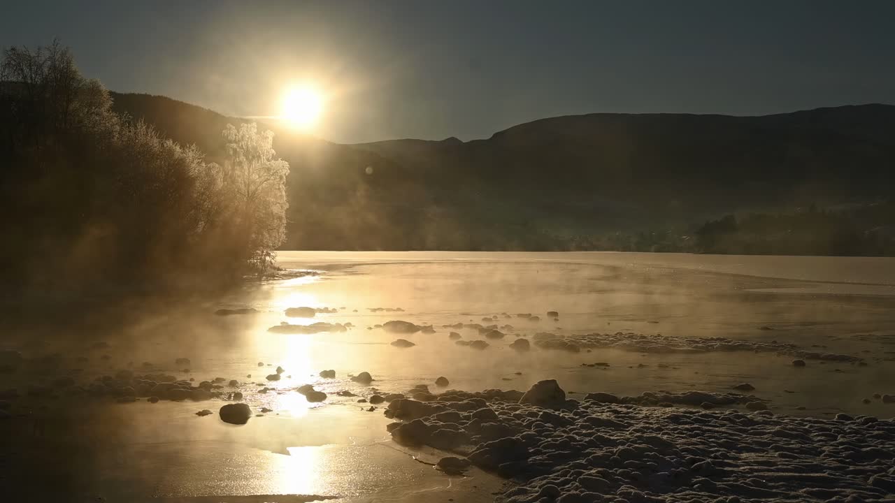 río helado y brumoso al atardecer con la silueta de la montaña voss, noruega