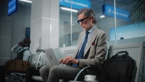 businessman working on laptop at airport