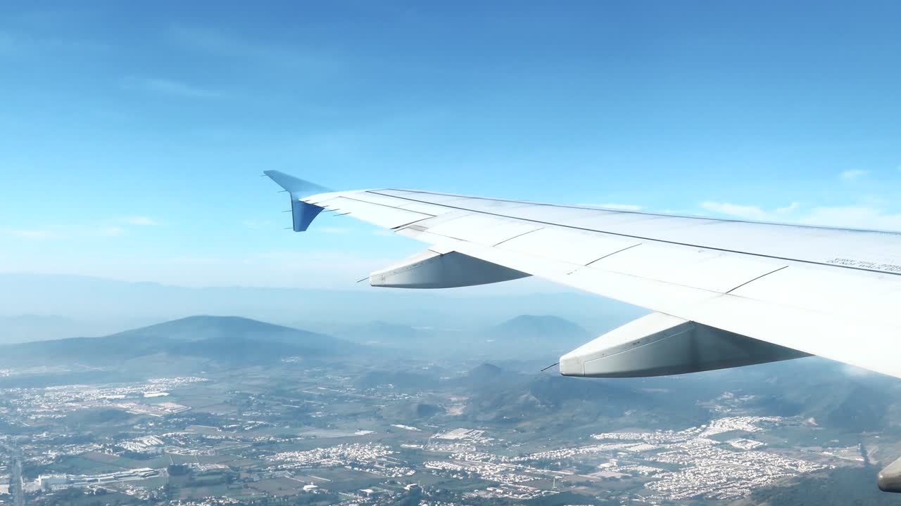 멕시코 북부의 도시와 산 위를 날아다니는 비행기 날개의 4k 뷰
