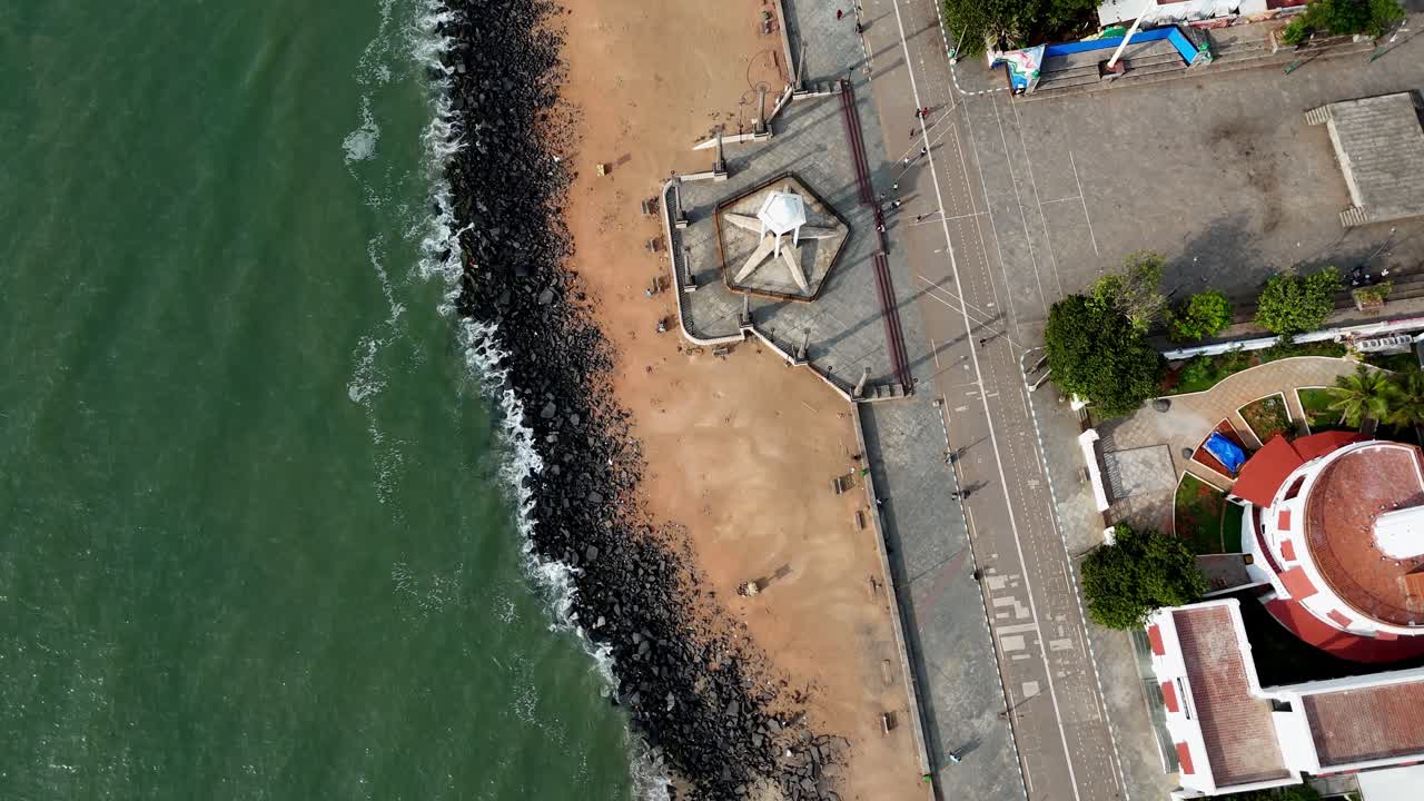 Early morning aerial footage of Puducherry's coastline highlights the Mahatma Gandhi statue, a prominent lighthouse, and the famous Rock Beach, with waves from the Bay of Bengal gently rolling in