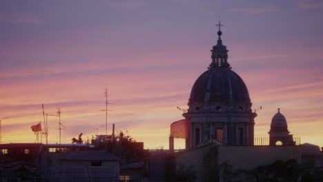 rooftops and dome of the basilica of ss. ambrose and charles on the corso at sunset in rome, italy