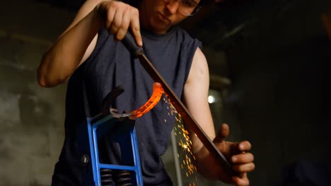 female metalsmith shaping horseshoe in factory 4k