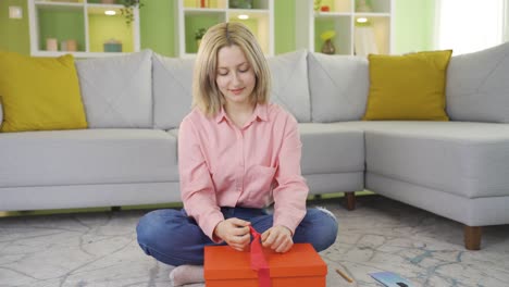 Young-girl-preparing-gift-wrap-and-leaving-a-note-on-it.