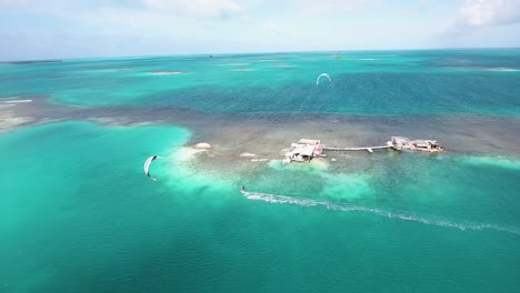 Zwei-Männer-Kiteboard-Kreuzen-Sich-Von-Rechts-Nach-Links,-Drohne-Geschossen-Palafito-Los-Roques