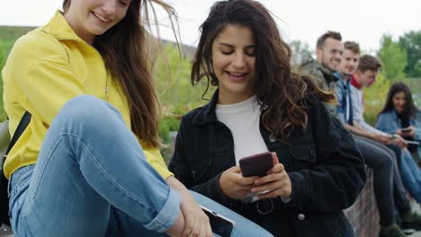 group of young people with smart phone spending time together