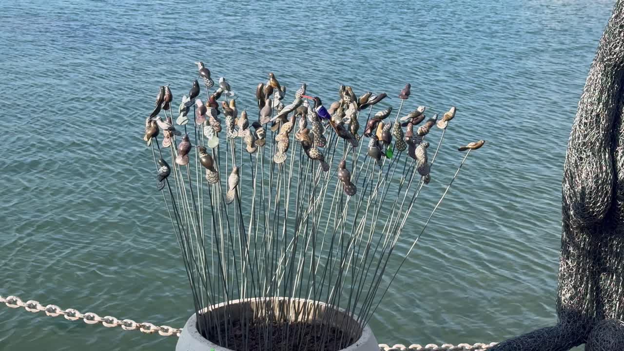Oggetti africani da collezione sullo sfondo dell'acqua blu in un porto a Città del Capo