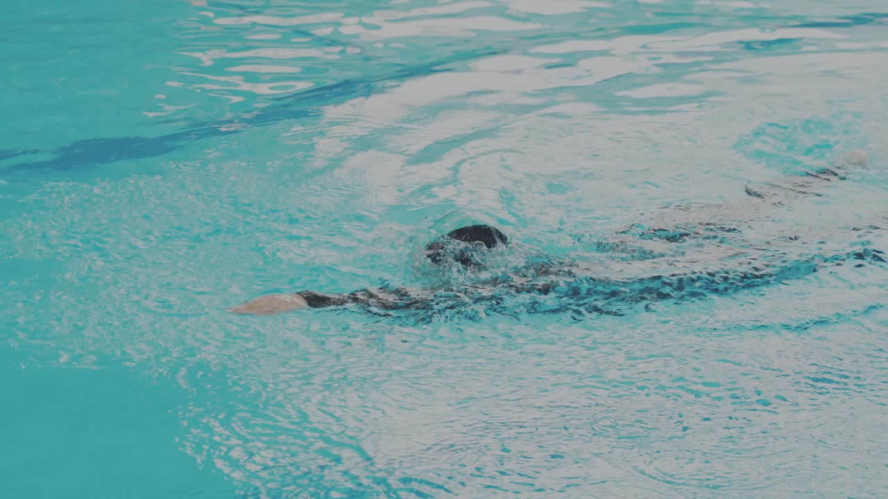 Tracking Shot Of Young Woman Swimmer Doing Freestyle In Swimming Pool