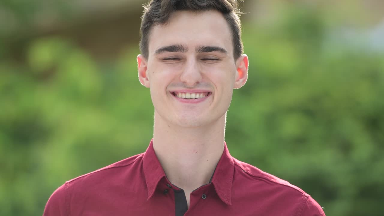 Young happy handsome businessman smiling in the streets outdoors