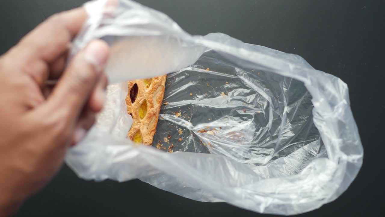 플라스틱 가방 에서 페이스트리 를 꺼내는 사람