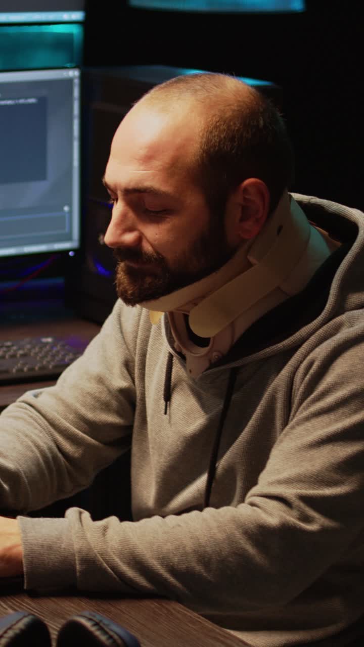 Vertical video: Young IT programmer wearing cervical collar at office