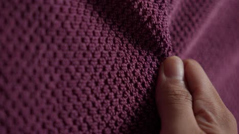 close-up of a person touching a soft purple fabric