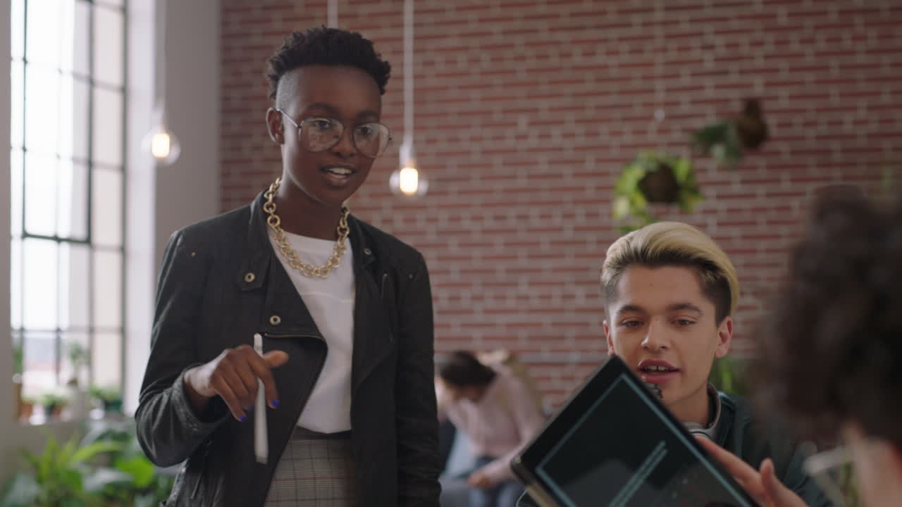 grupo creativo de estudiantes de negocios de lluvia de ideas utilizando computadora tableta digital líder del equipo afroamericano mujer compartiendo ideas colegas discutiendo proyecto en una oficina de moda diversa