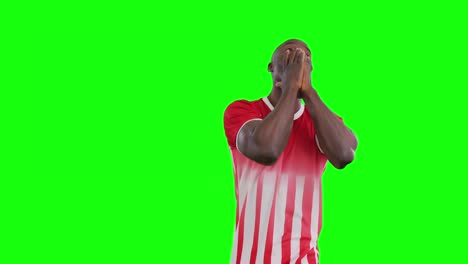 Video-of-smiling-african-american-male-soccer-player-cheering-on-green-screen-background