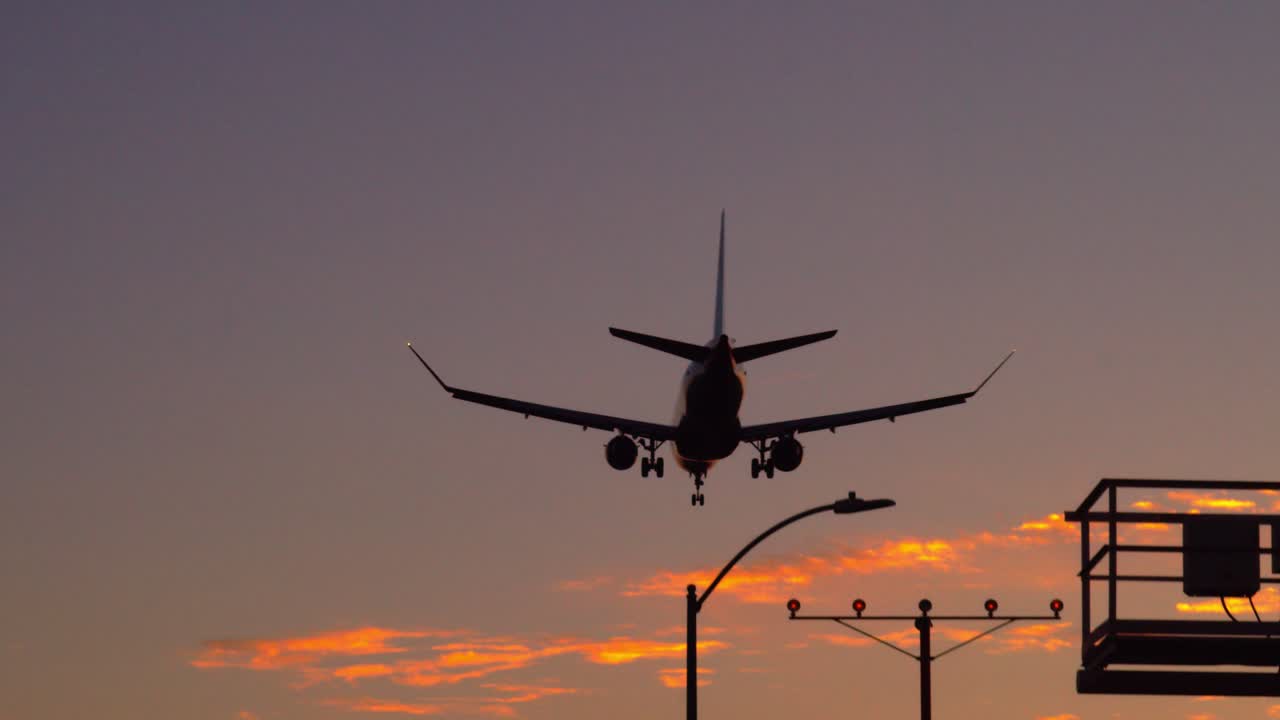 aterrizaje de avión contra un cielo de puesta de sol en el aeropuerto de lax - los ángeles - de derecha a izquierda