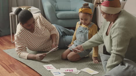 Mom and Granny Helping Little Schoolgirl Learning Alphabet