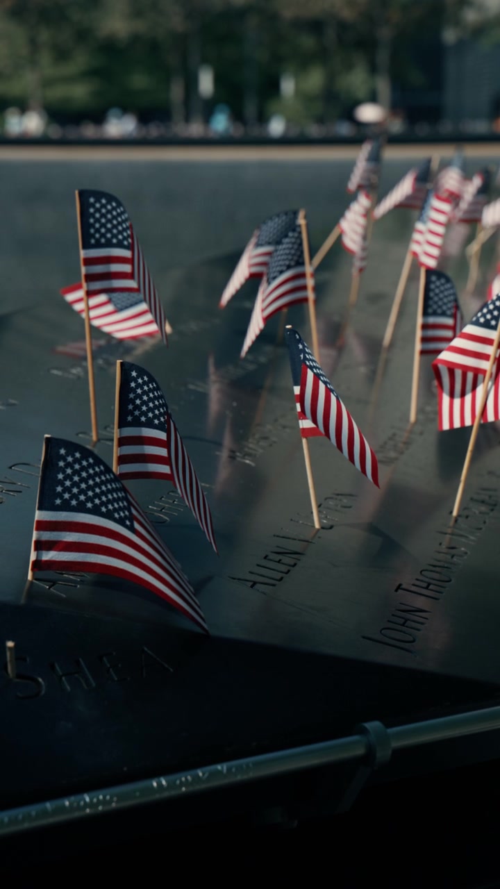 Rows of small American flags along memorial parapet