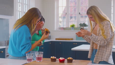 Gruppe-Teenager-Mädchen-Essen-Und-Haben-Spaß-Beim-Spielen-Mit-Cupcakes-In-Der-Heimischen-Küche