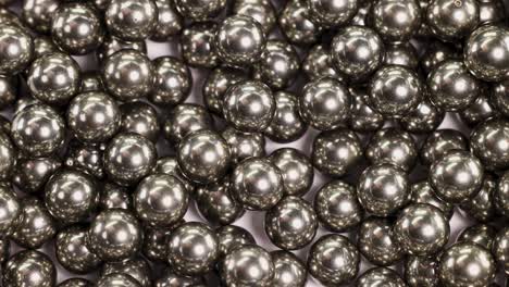 Close-up video of numerous ball bearings colliding and settling, showcasing metallic reflections and dynamic movement