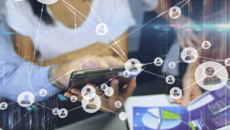 red de iconos de perfil contra la sección media de colegas de oficina que usan tableta digital en la oficina