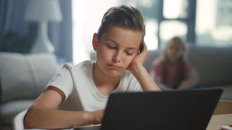 schoolboy using laptop for e-learning at home