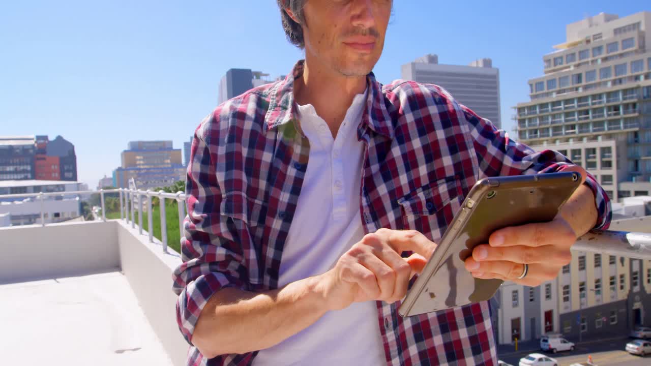 Male photographer using digital tablet in the terrace 4k