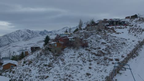 Aerial-rotating-shot-of-small-apartments-located-off-piste-at-Farellones,-Chile