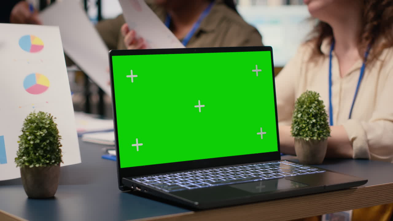 Green screen display on laptop during briefing meeting with female partners