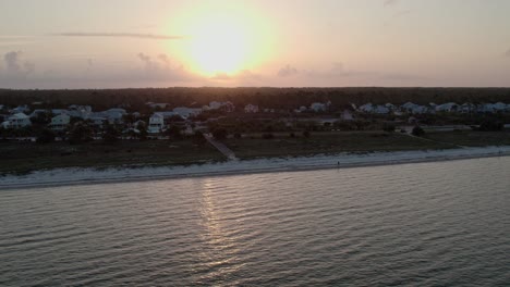 Aerial-panning-shot-of-numerous-homes-along-a-beach