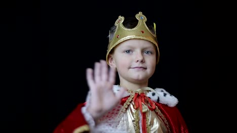 boy dressed as a king waving