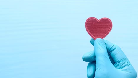 corazón rojo en un guante azul