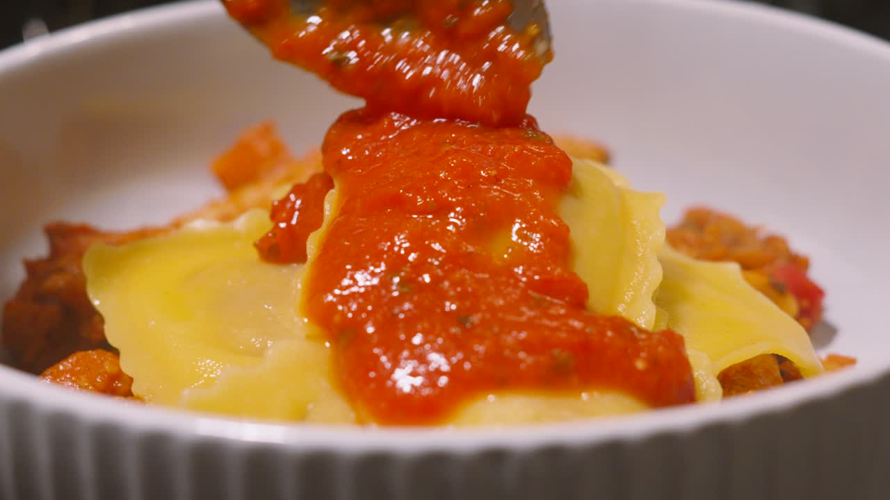 Tomato and Basil Sauce Being Drizzled on Ravioli Pasta to Add Flavour to Dish. Traditional Italian Food Cuisine Slow Motion Footage.