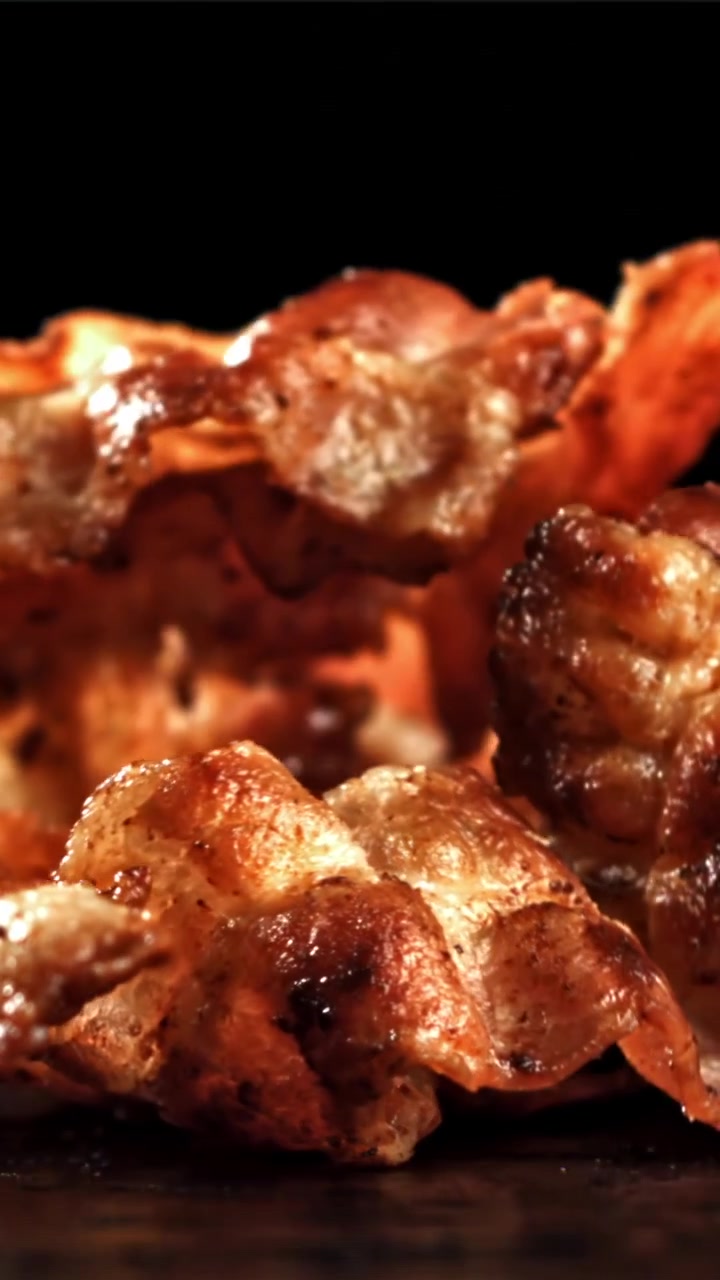Strisce di pancetta croccante che cadono al rallentatore